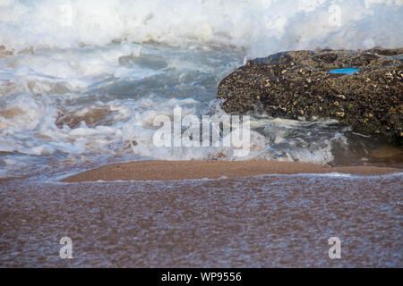 Starke nachmittag Ebbe und Flut mit Wellen, die auf den Felsen auf den Felsen mit stark schäumenden Wellen, eine Rückspülung, eine Seite waschen. Echten wütende Wellen. Stockfoto