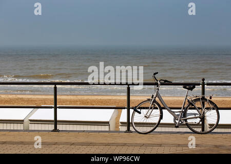 Fahrrad geparkt auf einem Zaun in der Nähe des Meeres in Middelkerke - Belgien Stockfoto