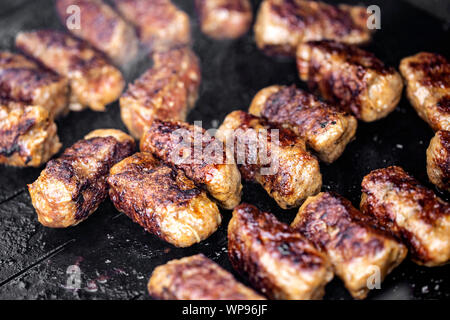 Gegrilltes Fleisch, Brötchen genannt Mici oder Mititei, traditionelle rumänische Speisen auf dem Grill in der freien Natur zubereitet Stockfoto