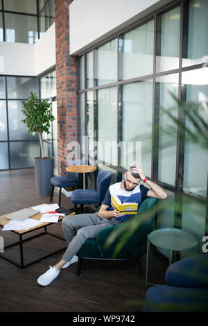 Blick von oben auf die junge vielversprechende Geschäftsmann arbeiten und studieren Stockfoto
