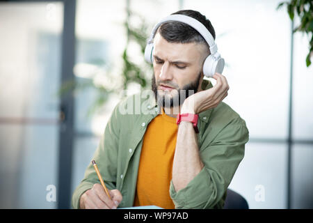 Junger Mann zuhören, um die Aufnahme und die test Bärtigen Stockfoto