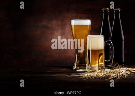 Flasche und zwei Gläser kalter golden Bier und Weizen ährchen auf dunklem Hintergrund. Kopieren Sie Platz Stockfoto