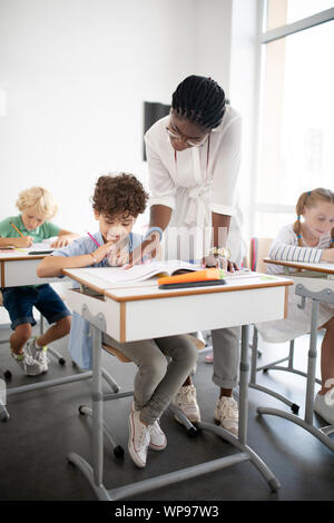 Afro-amerikanische Lehrer zu cute Curly boy kommen Stockfoto