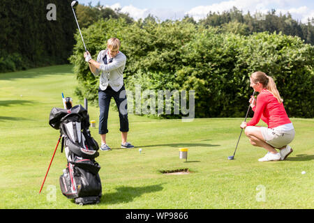 Männlicher Golfspieler putting Golf Ball auf dem Green Golf Stockfoto