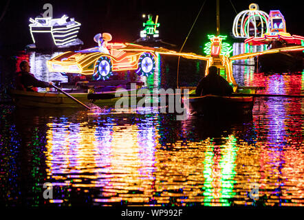 Eine Flotte von hell beleuchteten Booten gerudert sind den Fluss Derwent während der Matlock Bath Illuminationen, in der Peak District, die illuminationen wurden zum ersten Mal Queen Victoria Diamond Jubiläumsfeierlichkeiten im Jahre 1897 zu feiern. Stockfoto