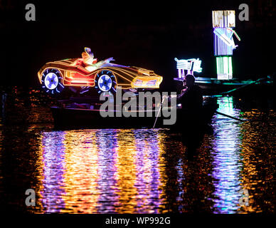 Eine Flotte von hell beleuchteten Booten gerudert sind den Fluss Derwent während der Matlock Bath Illuminationen, in der Peak District, die illuminationen wurden zum ersten Mal Queen Victoria Diamond Jubiläumsfeierlichkeiten im Jahre 1897 zu feiern. Stockfoto