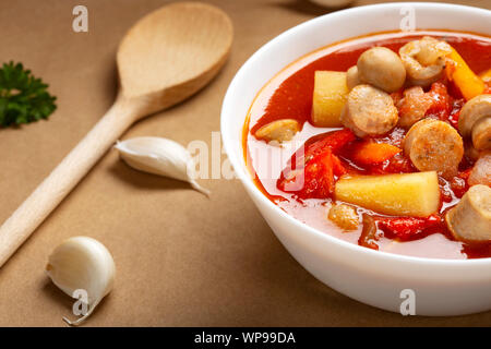 Eintopf oder Suppe aus Gemüse und deutsche Würstchen in einer weißen Schüssel gemacht Stockfoto