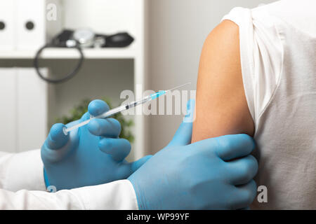 Arzt, Patient Impfstoff, Grippeimpfung. Arzt eine Impfung in der Schulter des Patienten Stockfoto