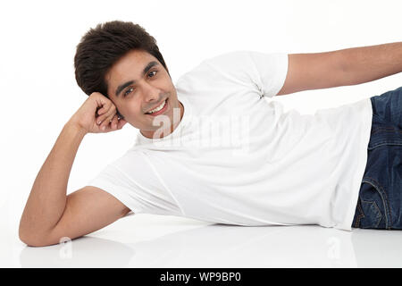 Junger Mann am Boden liegend und lächelnd Stockfoto