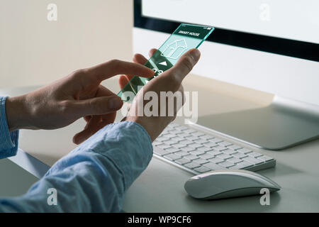 Ein Mann mit einem futuristischen transparente Telefon mit Anwendung für control Smart House. Stockfoto