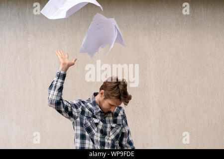 Jungen betonte Mann zerknittertes Papier Dateien in die Luft werfen, Freiheit Konzepte Stockfoto