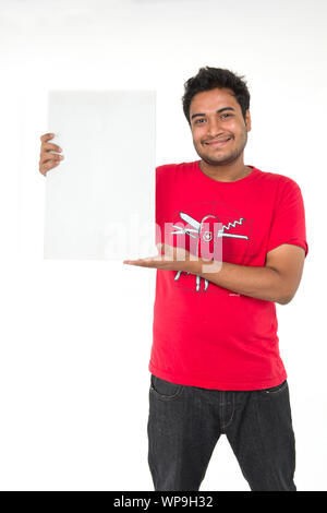 Junger Mann zeigt ein leeres Plakat Stockfoto