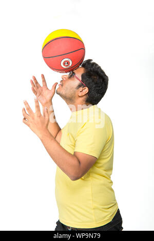 Junger Mann einen Basketball auf dem Kopf balancieren Stockfoto