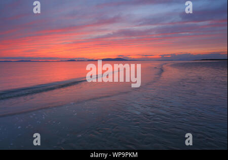 Sonnenuntergang über dem Meer und eine Flut an Allonby, Cumbria, England, Vereinigtes Königreich. Stockfoto