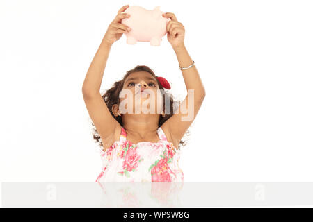 Mädchen schütteln Sparschwein Stockfoto