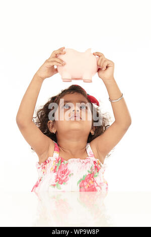 Mädchen schütteln Sparschwein Stockfoto