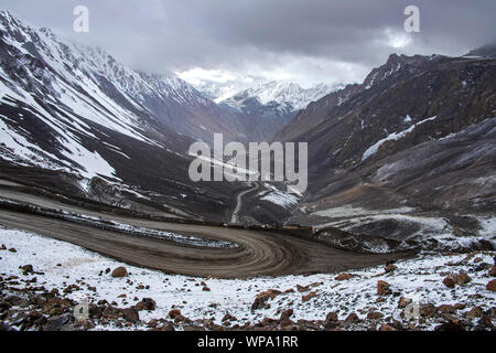 Blick von oben auf eine Serpentine Mountain Road zwischen schneebedeckten Hügeln. Kirgisistan Stockfoto