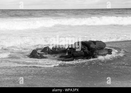 Tide ist in. Teufelskreis Kurven mit der Flut Absturz vor der Küste mit einem sehr starken Rückspülung. Die Brandung ist Schaumig an einem bewölkten Tag. Stockfoto