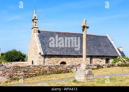 Seitenansicht der Granit Kapelle von Saint-Nicolas in Bugueles, Bretagne, Frankreich, mit seinen Ummauerten Kirchhof und Kalvarienberg auf der Seite eines kleinen Landes Stockfoto