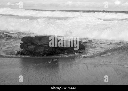 Tide ist in. Teufelskreis Kurven mit der Flut Absturz vor der Küste mit einem sehr starken Rückspülung. Die Brandung ist Schaumig an einem bewölkten Tag. Stockfoto