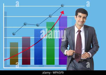 Geschäftsmann, der vor dem nach oben steigenden Balkendiagramm steht Stockfoto