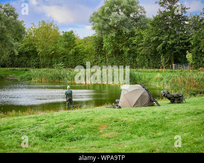 Angler verbringen ihre Freizeit Angeln als Hobby an der Seite von Culverthorpe See in der Nähe von Grantham in Lincolnshire mit Zelt wie Unterstände Stockfoto