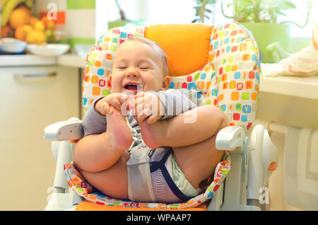 Smiling baby Junge im Hochstuhl sitzen Stockfoto