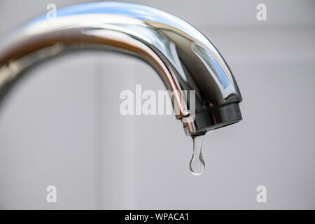 Sauberes Wasser Tropfen von Fallen, einen tropfenden Wasserhahn Küche, eine unnötige Verschwendung von Wasser in einer Welt, die von Wasserknappheit bedroht. Stockfoto