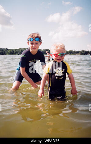 Zwei Jungen in Nass-Anzüge in Frensham Teiche, Surrey, England, Vereinigtes Königreich. Stockfoto