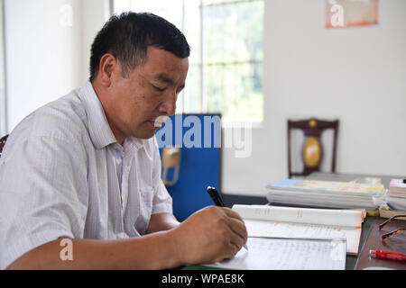 (190908) -- TIANDONG, Sept. 8, 2019 (Xinhua) - Wei Guoji bereitet den Unterricht in der Grundschule am Tuogua Tuogua Dorf in Zuodeng Yao ethnischen Gemeinde Tiandong County, South China Guangxi Zhuang autonomen Region, Sept. 3, 2019. In den abgelegenen Bergen County, Tiandong Tuogua Grundschule ist über 60 km entfernt von der Kreisstadt, die nur noch mit einem robusten Mountain Road führen kann. Die 53-jährige Wei Guoji, ein Eingeborener ins Dorf, ist das Prinzip der Dorfschule. Wei wurde als Ersatz Lehrer der Schule rekrutiert nach Abschluss der Junior High School an Stockfoto