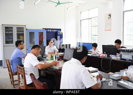 (190908) -- TIANDONG, Sept. 8, 2019 (Xinhua) - Wei Guoji (C) diskutiert mit anderen Lehrern der Schule in Tuogua Tuogua Dorf in Zuodeng Yao ethnischen Gemeinde Tiandong County, South China Guangxi Zhuang autonomen Region, Sept. 3, 2019. In den abgelegenen Bergen County, Tiandong Tuogua Grundschule ist über 60 km entfernt von der Kreisstadt, die nur noch mit einem robusten Mountain Road führen kann. Die 53-jährige Wei Guoji, ein Eingeborener ins Dorf, ist das Prinzip der Dorfschule. Wei wurde als Ersatz Lehrer der Schule rekrutiert nach Staffelung von Junior Stockfoto