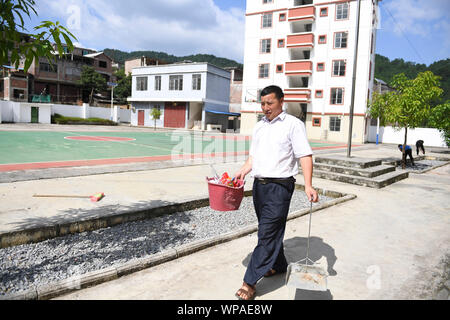 (190908) -- TIANDONG, Sept. 8, 2019 (Xinhua) - Wei Guoji reinigt den Campus an der Schule in Tuogua Tuogua Dorf in Zuodeng Yao ethnischen Gemeinde Tiandong County, South China Guangxi Zhuang autonomen Region, Sept. 3, 2019. In den abgelegenen Bergen County, Tiandong Tuogua Grundschule ist über 60 km entfernt von der Kreisstadt, die nur noch mit einem robusten Mountain Road führen kann. Die 53-jährige Wei Guoji, ein Eingeborener ins Dorf, ist das Prinzip der Dorfschule. Wei wurde als Ersatz Lehrer der Schule nach Abschluss der Junior High School im Alter von 18 Jahren rekrutiert Stockfoto