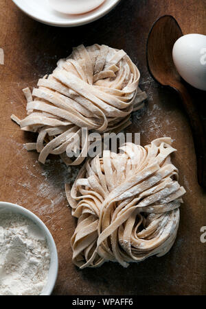 Hausgemachte frische Pasta gerollt und Trocknung auf Schneidebrett Stockfoto