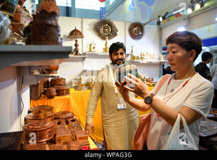 (190908) - YINCHUAN, Sept. 8, 2019 (Xinhua) - ein Besucher (R) wählt Produkte aus Pakistan während der 4. China-Arab Staaten Expo in Yinchuan, Nordwesten Chinas autonomen Region Ningxia Hui, Sept. 7, 2019. Die Besucher haben von Kunsthandwerk aus paricipating Länder und Regionen auf der Expo geblendet worden. (Xinhua / Feng Kaihua) Stockfoto