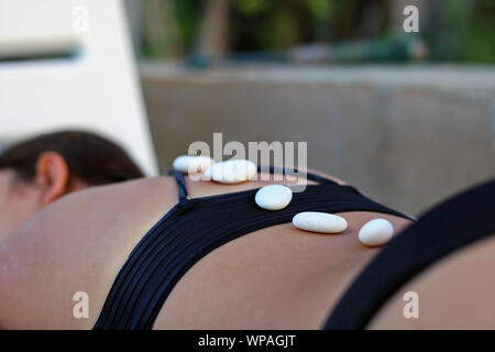 Spa und Health Concept - Schöne junge Frau in einem Salon Spa liegt in Hot Stone Massage. Stockfoto