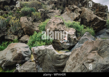 Man Klettern ein Stein in der Mitte eines vulkanischen Landschaft Stockfoto