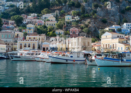 Insel Symi, Griechenland, Europa, August 2019. Blick auf das Dorf Zentrum mit dem Hafen und den farbigen Gebäude und Häuser Stockfoto