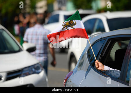 Ein Kind stolz Wellen der iranischen Löwe und Sonne (hir o Khorshid") Fahne aus einem Fenster am oberen auf der Yonge persischen Parade. Stockfoto