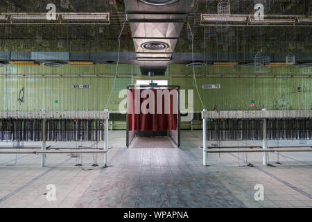 Alte Verlassen der Fabrik oder Industriegebäude mit kompletter Ausstattung horizontale Reihe hängenden Ketten, Teil der Maschine, vor der weissen Tafel. Stockfoto