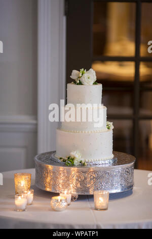 Schöne drei tiered Hochzeit Kuchen mit Kerzen. Stockfoto