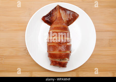 Gegrillter Tintenfisch mit Teriyaki Sauce auf dem Teller auf dem Tisch isoliert Stockfoto