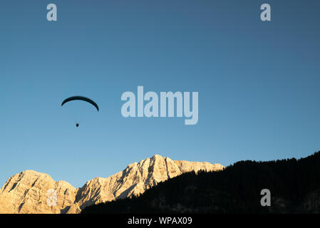 Silhouette von Gleitschirm in die Dolomiten Landschaft im Abendlicht in der Nähe von La Valle Stockfoto