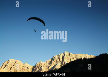 Silhouette von Gleitschirm in die Dolomiten Landschaft im Abendlicht in der Nähe von La Valle Stockfoto