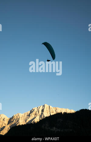 Silhouette von Gleitschirm in die Dolomiten Landschaft im Abendlicht in der Nähe von La Valle Stockfoto