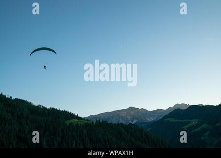 Silhouette von Gleitschirm in die Dolomiten Landschaft im Abendlicht in der Nähe von La Valle Stockfoto