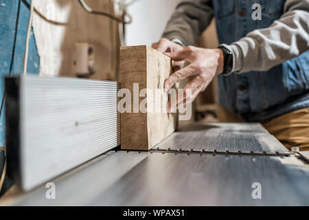 Kaukasische Mann, Teile aus Holz für Möbel auf Machine Tool namens dicke Hobel in der Schreinerei. Die Herstellung von Schnittholz Konzept Stockfoto