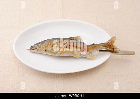 Gegrillter Fisch mit Salz sweetfish Japanische Gerichte Ayu no shioyaki auf dem Teller auf dem Tisch isoliert Stockfoto