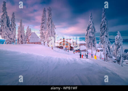 Spektakuläre Winter Skigebiet mit Skifahrer in Rumänien. Fantastische touristischen und Wintersport Urlaub Lage. Schönen Sonnenuntergang in Poiana Brasov Ski Res Stockfoto