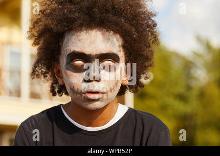 Kopf und Schultern Porträt des Afrikaners - kaufen Sie tragen gruselige Skelett Kostüm posiert im Freien auf Halloween durch Sonnenlicht beleuchtet, kopieren Raum Stockfoto