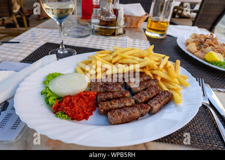 Traditionelle kroatische Balkan cevapcici Abendessen mit fies Ajvar und Zwiebel Stockfoto